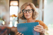 © BusinessClass by W61 - Mature woman using tablet PC sitting at home