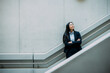 © BusinessClass by W61 - Businesswoman with arms crossed leaning on staircase railing at workplace