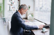 © BusinessClass by W61 - Mature businessman reading newspaper at cafe