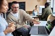 © BusinessClass by W61 - Businessman with disability having discussion over new computer software on laptop with businesswoman at desk