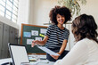 © BusinessClass by W61 - Smiling businesswoman explaining report to colleague at office