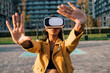 Young woman gesturing with virtual reality simulator on sunny day