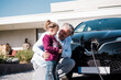 © BusinessClass by W61 - Happy man with daughter holding electric plug in front of car