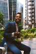 Smiling mature businessman sitting with bowl of salad at office park