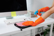 © crizzystudio - Cleaning lady disinfecting office desk with spray and cloth