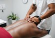 © Jazzy - African american man reciving back massage at the clinic.