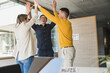 © BusinessClass by W61 - Happy business people standing together with raised arms in office