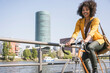 © BusinessClass by W61 - Happy businesswoman riding bicycle by River Main on sunny day