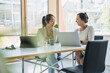 © BusinessClass by W61 - Smiling mature businesswoman with colleague discussing over laptop in office