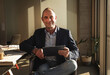 © BusinessClass by W61 - Smiling mature businessman sitting with tablet PC in office