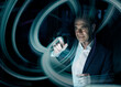 © BusinessClass by W61 - Digital composite image of businessman creating swirl pattern on graphical user interface