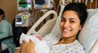 © Nuraya - Joyful new mother cradles her newborn baby in hospital bed, beaming with happiness surrounded by medical equipment