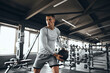 © Davidovici - Horizontal photo of a fit male athlete training with a medicine ball at the gym. The strong young man is performing a strength exercise using the fitness ball.