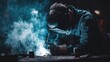 © raniekadm - Focused welder in smoky workshop