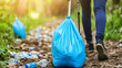 © TUL - Environmentally conscious person holding blue plastic bag filled with litter and waste materials