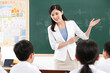 © ding - Young beautiful female teacher teaching students in the classroom