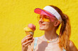 © st.kolesnikov - Happy Woman Enjoying Ice Cream Cone on Hot Summer Day with Bright Yellow Background