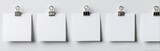 Blank square note papers attached to a wall with binder clips