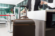 © amorn - Airport and passenger concept. Woman airline ground staff helping traveler with checkin at terminal counter