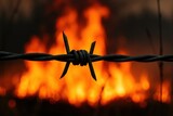 A solitary barbed wire fence stands as a stark reminder of confinement amidst chaos