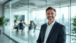 © abu - Confident executive stands before a glass meeting room in a modern office.