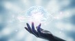 © fledermausstudio - A hand holds a glowing blue brain with orbiting light particles