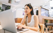 © dodotone - Young asian woman sitting indoors cafe using laptop influencer gen z modern lifestyles