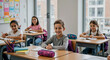 © dubogray1985 - Smiling school children sitting at desks in bright modern classroom