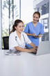 © SOMKID - Female doctor and nurse working together with clipboard and laptop for in modern clinic.