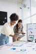 © SOMKID - Two business woman working together for analysis data plan business strategies at desk in office, Business discussing and startup concept.