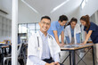 © SOMKID - A male doctor smiling looking at the camera in meeting room, Medical team reviewing data.