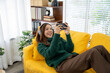 © Kritdanai - Gamer Girl on a Yellow Sofa: A young woman engrossed in mobile gaming, relaxing on a vibrant yellow sofa, showcasing a modern lifestyle and the joy of digital entertainment.