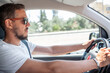 © Anat art - Man Driving a Vehicle Through a Sunny Street With Focus and Concentration on the Road Ahead During Daytime