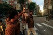 © bernardbodo - Group of friends giving high five crossing the street at sunset