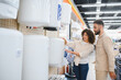 © Serhii - Couple choosing water heater in electronics store