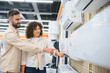 © Serhii - Couple choosing air conditioner in electronics store
