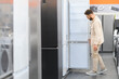 © Serhii - Customer choosing refrigerator in electronics store appliance department