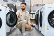 © Serhii - Customer choosing washing machine in electronics store