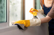 © Natee Meepian - Window Cleaning. Person spraying and wiping glass with cloth.