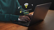 © ParinPIX - Person using a laptop computer with slow internet connection icon and loading screen interface. Concept of technology delay, network issues, data buffering and low Wi-Fi signal during online activity.