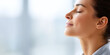 © GrayFrog - Woman with closed eyes taking a deep breath and enjoying a moment of calm and relaxation in soft natural light.