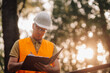 © Ljustina - Engineer taking notes outdoors during golden hour sunset