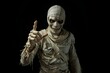 © Paull - Halloween mummy points the finger. One hand of mummy points a finger on black background.
