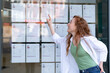 © Iryna - Young woman pointing at activity notice board in urban area during daylight near busy street