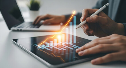 Wall Mural - close-up of hands using stylus on tablet displaying upward trending bar graph, showcasing business g