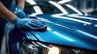 © sumon78 - Car detailing with blue gloves polishing shiny blue car hood using microfiber cloth in auto body shop, reflecting bright lights and clean surface with care and precision