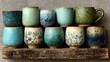 © Artsaba Family - Ceramic teacups sit on a rustic wooden shelf, showcasing unique glazes and hand-painted floral stoneware. The aesthetic emphasizes artisan pottery and craftsmanship
