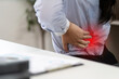 © Natee Meepian - Office Syndrome: Woman Experiencing Lower Back Pain While Working