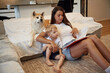 © standret - Learning to read, with book. Mother with son and Shibu Inu dog are at home