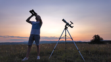 Wall Mural - amateur astronomer using telescope and binoculars for watching stars, moon, planets and other celest